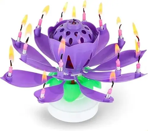 Vela de cumpleaños en forma de flor de loto color morado abierto con pétalos extendidos y velas encendidas en cada punta.