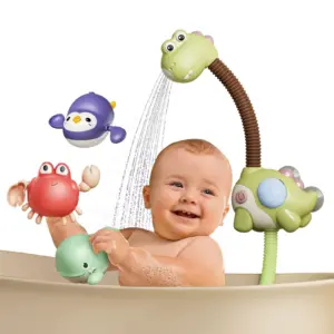 Bebé sonriente en tina jugando con ducha eléctrica verde de dinosaurio, incluye juguetes flotantes de cangrejo rojo, pingüino morado y ballena verde.