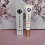 Crema antimanchas Bioaqua en tubo blanco con tapa dorada y su caja original sobre superficie rosada con fondo floral.