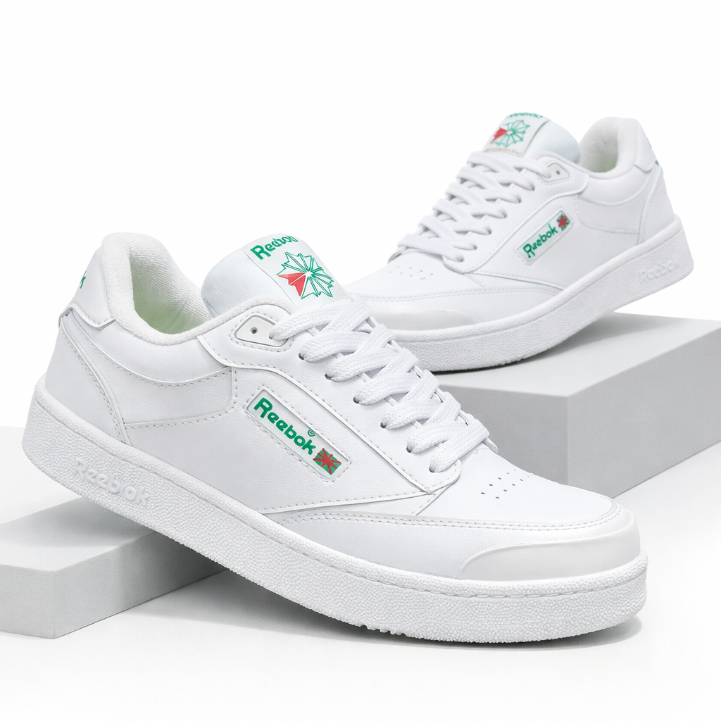 Zapatillas Reebok Club blancas de corte bajo con detalles en verde y rojo, mostradas en ángulo sobre pedestales blancos.