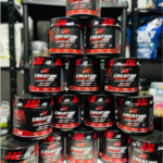 Piramides de botes negros con etiqueta roja de creatina en polvo Iron Creatine Plus de 500g sobre estanteria.