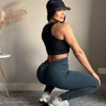 Leggings push up deportivos de tiro alto color azul petróleo que realzan los glúteos, usados por mujer en posición de sentadilla.