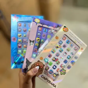 Mano sosteniendo tres cajas holográficas de celulares didácticos infantiles con diseños de Stitch, Kuromi y Capybara para aprendizaje temprano.