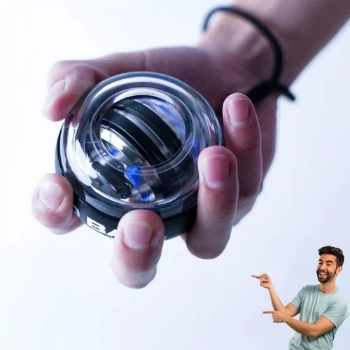 Mano sosteniendo ejercitador giroscópico transparente para muñeca con núcleo metálico y luz azul interior para fortalecer antebrazos.