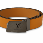 Correa Louis Vuitton de neotextil color naranja con hebilla metálica oscura grabada con el logo, mostrada en posición enrollada.