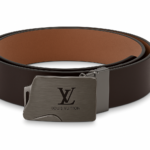 Correa reversible Louis Vuitton de neotextil con hebilla metálica mate grabada, en tonos marrón oscuro y café claro, vista en ángulo.