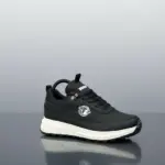 Tenis casual Brahma negro en material sintético con suela blanca de PVC, vista lateral derecha y diseño acolchado para uso diario.