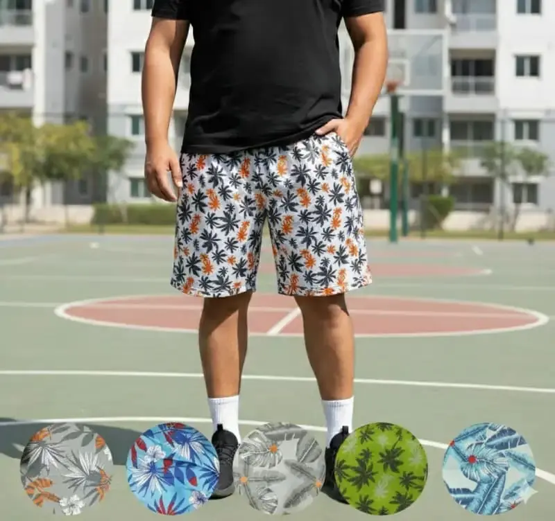 Pantaloneta cargo de viaje para hombre con estampado tropical blanco, negro y naranja, mostrando cinco variantes de colores y patrones botánicos.