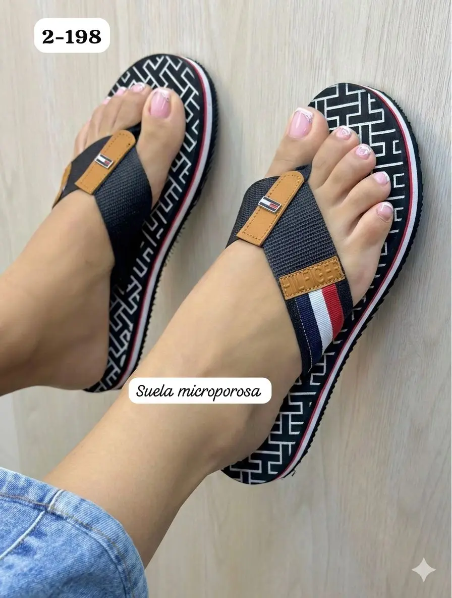 Sandalias Tommy Hilfiger para dama estilo thong con suela microporosa negra, patrón geométrico y correas con los colores de la marca.