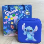 Estuche rígido azul con cierre y estampado de Stitch junto a bolsa de regalo temática azul sobre superficie de madera clara.