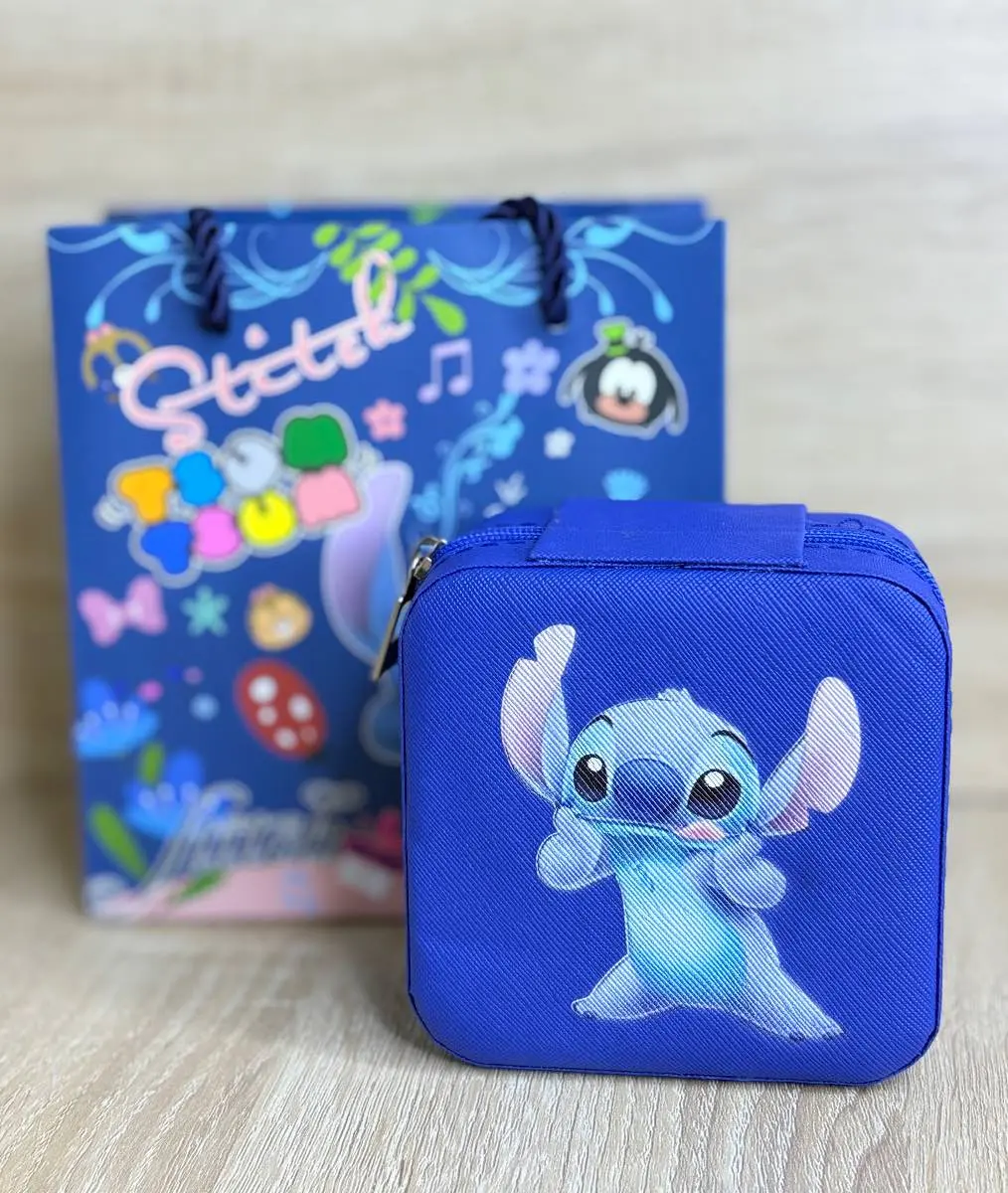Estuche rígido azul con cierre y estampado de Stitch junto a bolsa de regalo temática azul sobre superficie de madera clara.