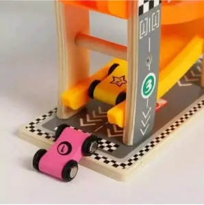 Pista didáctica de madera con niveles amarillos, incluye un auto rosado marcado con el número uno y otro amarillo con una estrella en la base.