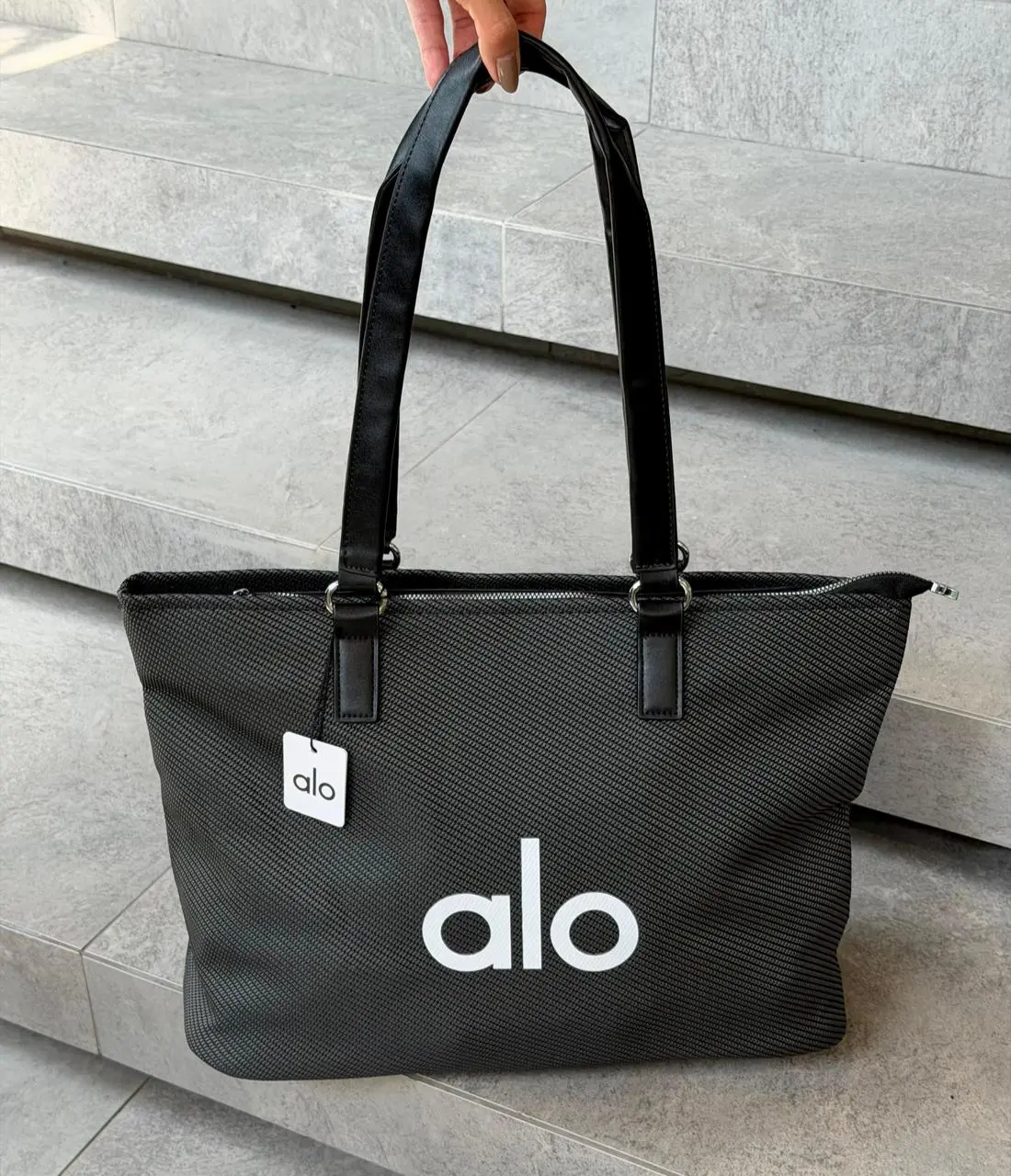 Bolso tote negro Alo de gran capacidad con textura acanalada, asas de cuero sintético y logotipo blanco frontal.