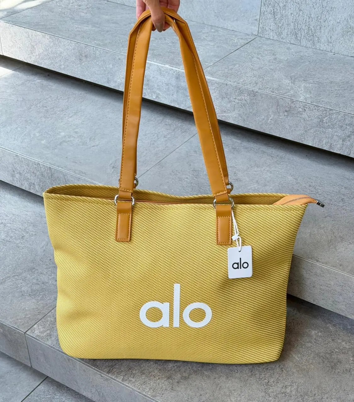 Bolso tote amarillo Alo grande de gran capacidad con textura tejida, asas de cuero sintético y cierre de cremallera superior.