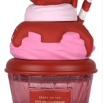 Perfume Lattafa en frasco de vidrio rosa con forma de cupcake, decorado con fresa y sirope rojo.