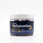 Envase cilíndrico transparente con gomas oscuras de melatonina, etiqueta azul nocturna con luna, estrellas y texto en blanco.