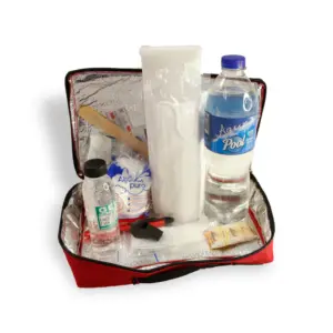 Botiquín térmico de emergencia rojo abierto, mostrando interior metalizado, botella de agua, frasco, mascarillas, silbato y suministros médicos.