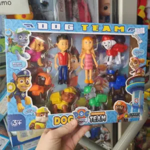 Caja con set de figuras coleccionables de Paw Patrol, incluye dos muñecos humanos y seis cachorros de plástico multicolores.