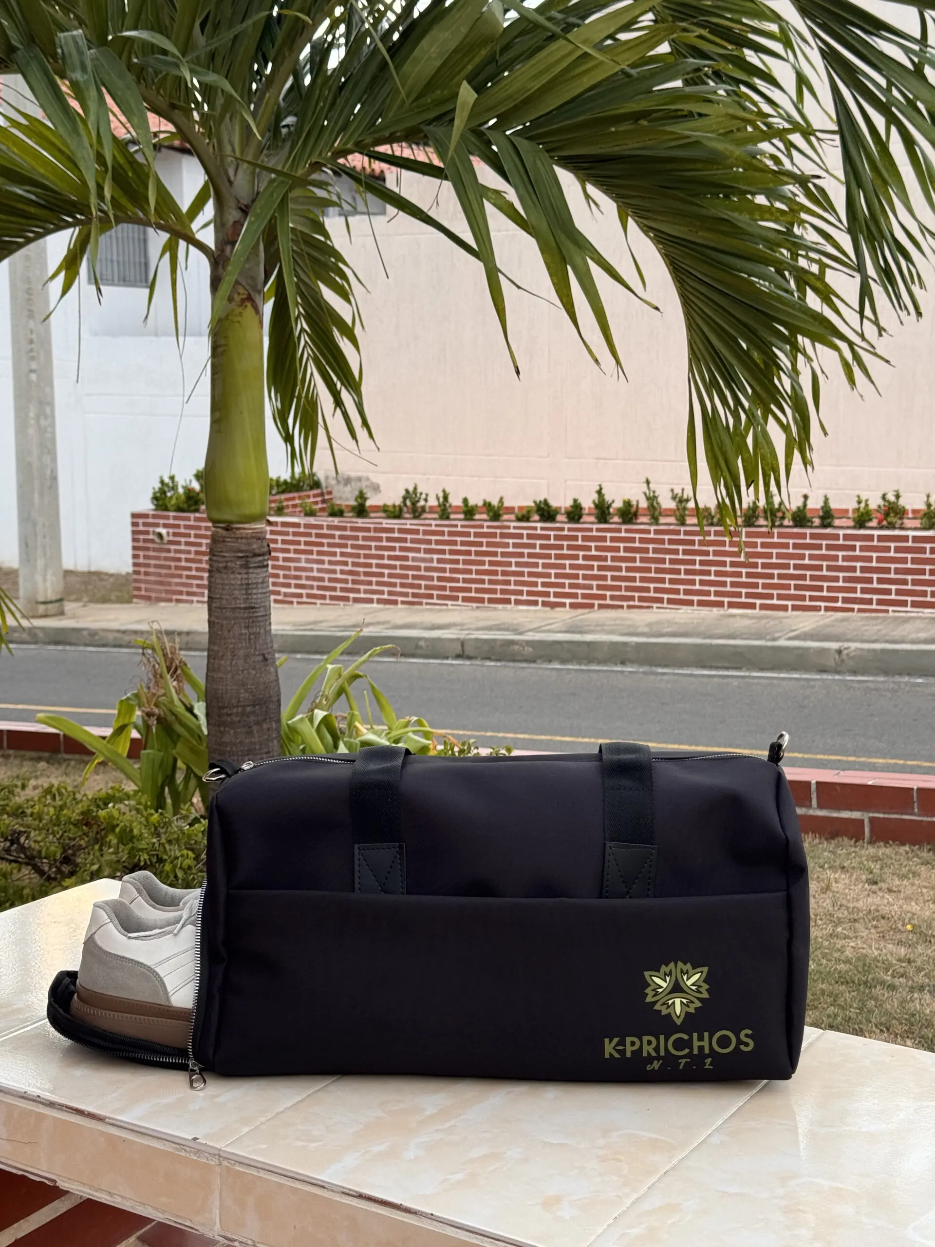 Bolso de lona negro unisex con compartimento lateral abierto para zapatos sobre superficie clara al aire libre
