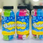 Tres envases plásticos de burbujero con tapa negra, etiquetas azules con la palabra Bubble y sobres de colores verde, rosado y azul en su interior.