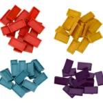 Fichas de dominó de plástico en colores rojo, amarillo, azul y morado, organizadas en cuatro grupos con vista superior sobre fondo blanco.
