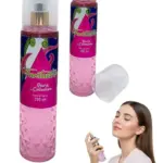 Dos botellas de spray corporal color rosa con textura de diamantes, una con tapa, y una mujer aplicándose la fragancia.