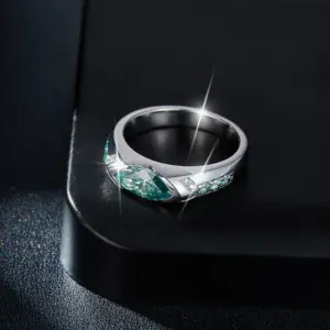 Anillo de moisanita verde en plata 925 con diseño lateral brillante sobre superficie negra.