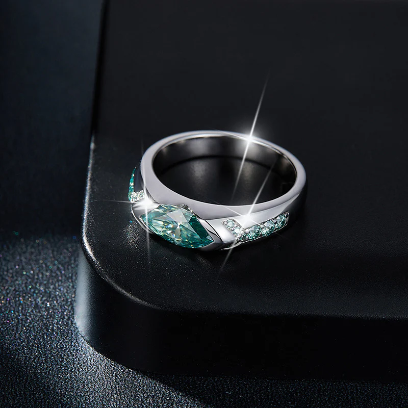Anillo de moisanita verde en plata 925 con diseño lateral brillante sobre superficie negra.