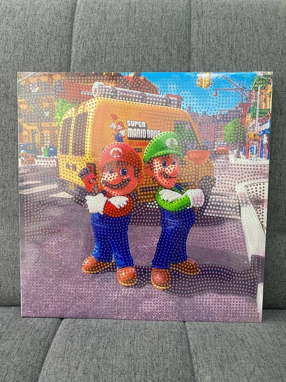 Pintura diamante 3D con diseño de Mario y Luigi frente a una camioneta amarilla, con textura de cuentas brillantes y coloridas.