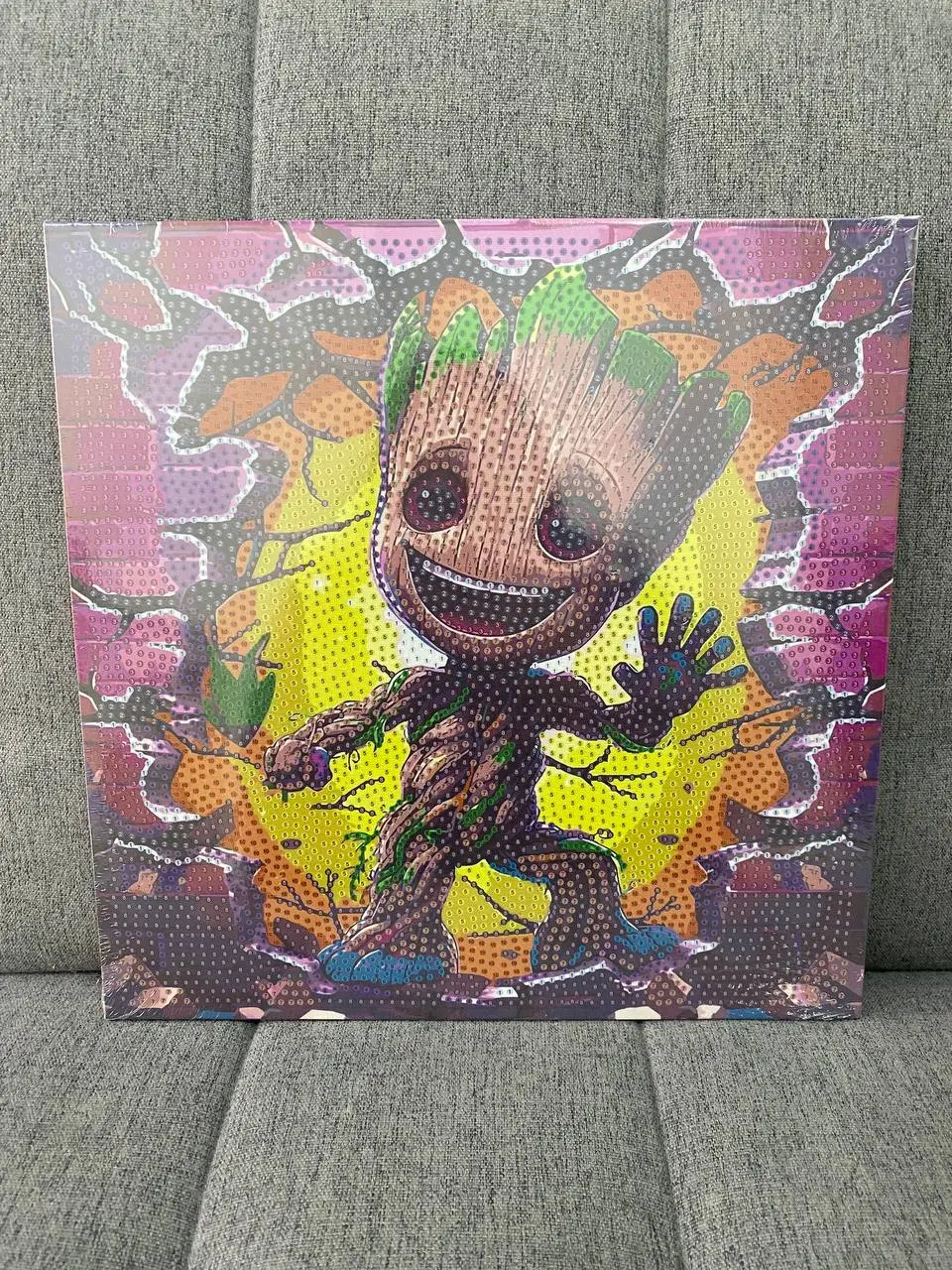 Kit de pintura diamante 3D con diseño de Baby Groot sonriente, fondo amarillo y detalles morados, con textura de cuentas brillantes.