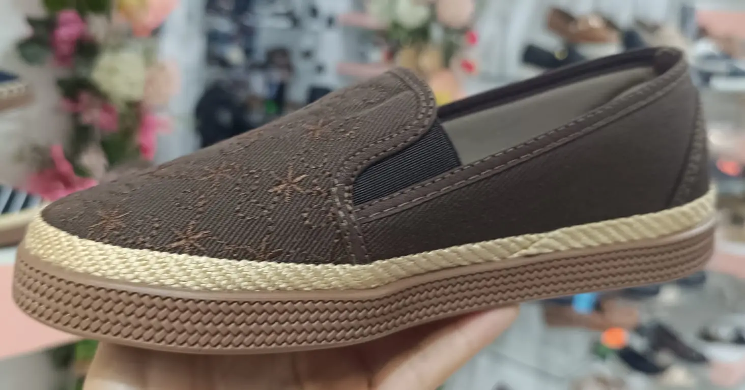 Zapato casual femenino café tipo alpargata con diseño bordado, elásticos laterales y suela de yute con plataforma texturizada.
