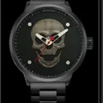 Reloj analógico negro mate con esfera oscura, calavera metálica en relieve y detalles rojos en las manecillas, variante plateada.