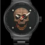 Reloj analógico negro mate con esfera de calavera en relieve metálico color oro rosa y manecillas luminosas.