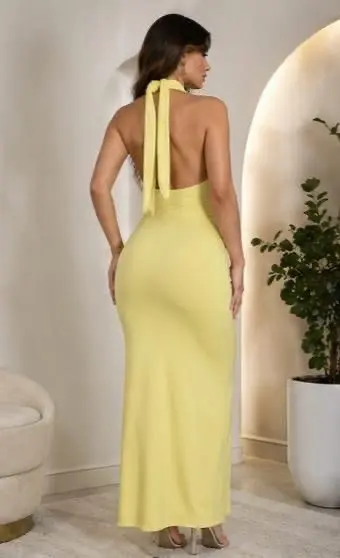 Vestido largo halter amarillo de acetato licra con fruncido trasero y espalda descubierta, visto desde atrás en un evento formal.