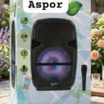 Empaque de parlante profesional Aspor con luz LED morada, incluye micrófono y control remoto, en un entorno de jardín con flores.