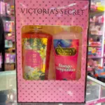 Kit Victoria's Secret Mango Temptation en caja rosa con ventana, incluye fragancia en spray y crema corporal con diseño tropical.