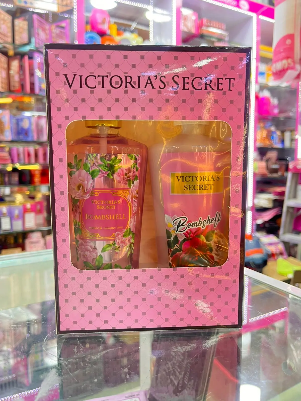 Kit Victoria's Secret Bombshell con splash y crema corporal en caja rosa con patrón de puntos y ventana transparente.