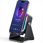 Soporte altavoz inalámbrico negro con luces RGB laterales, sosteniendo un smartphone en posición inclinada para escritorio.