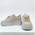 Zapatillas Puma de plataforma en carnaza color beige claro con pedrería y perlas decorativas, vista lateral y frontal.