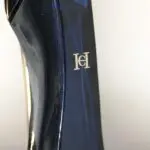 Perfume Carolina Herrera Good Girl en frasco con forma de zapato de tacón alto en tono azul oscuro brillante y logotipo dorado en relieve.