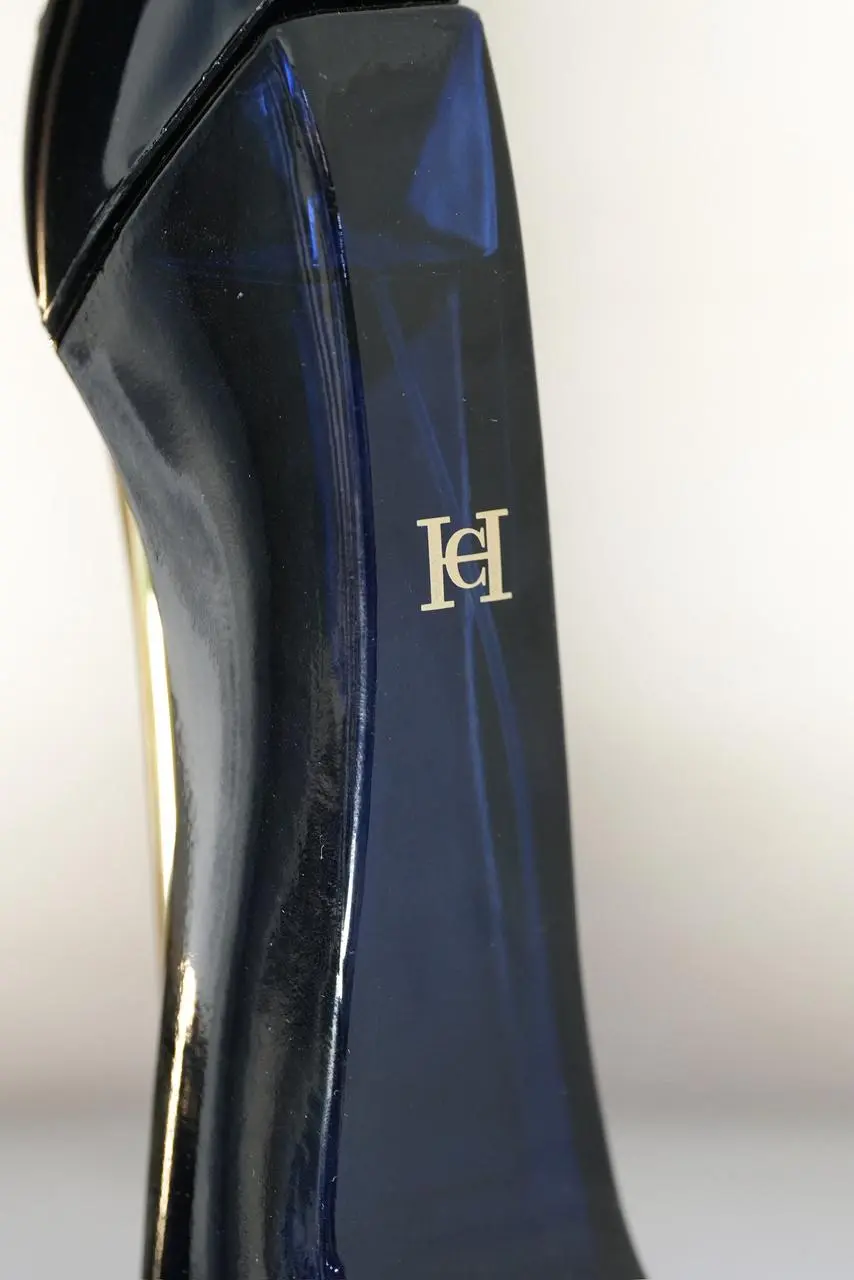 Perfume Carolina Herrera Good Girl en frasco con forma de zapato de tacón alto en tono azul oscuro brillante y logotipo dorado en relieve.
