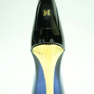 Perfume Carolina Herrera Good Girl en frasco con forma de tacón alto negro y aguja dorada, vista cenital del talón.