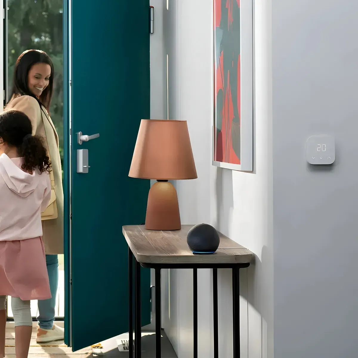 Parlante inalámbrico bluetooth portátil negro en mesa de madera junto a lámpara terracota y termostato en la pared.