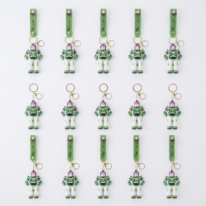 Llaveros de silicona 3D de Buzz Lightyear en verde, blanco y morado, con correas o argollas, organizados en filas sobre fondo blanco.