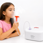 Niña usando nebulizador compresor médico Jziki blanco con mascarilla transparente y vapor para tratamiento respiratorio en casa.