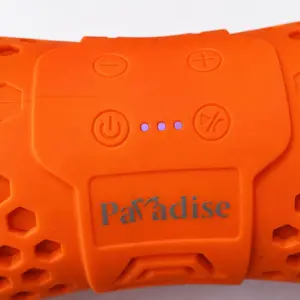 Primer plano de parlante portátil naranja con textura de panal, botones de control, luces LED moradas y marca Paradise.