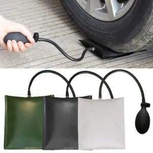 Cuña inflable de aire negra soportando el peso de una llanta de carro, con pera de inflado manual y manguera. Abajo se muestran tres versiones en colores verde, negro y gris claro.