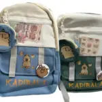 Morral escolar y ejecutivo azul o verde claro con diseño de capibara, bolsillo frontal de malla, solapa con broche y monedero redondo colgante.