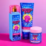 Kit de aseo Y2K en tonos azules y fucsias sobre fondo rosa. Incluye body mist de 250ml, loción corporal de 250ml y manteca corporal de 150ml con diseño brillante de anillo de caramelo.