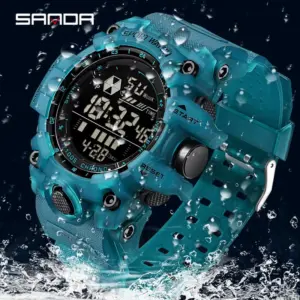 Reloj táctico deportivo digital Sanda en color verde azulado sumergido parcialmente en agua, diseño robusto de alta resistencia y pantalla digital iluminada.